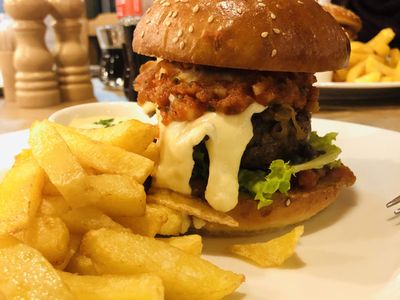 Cheeseburger s bio sýrem, se slaninou, rajčatovým chutney, zeleninou, hranolkami a „olivovou“ majonézou